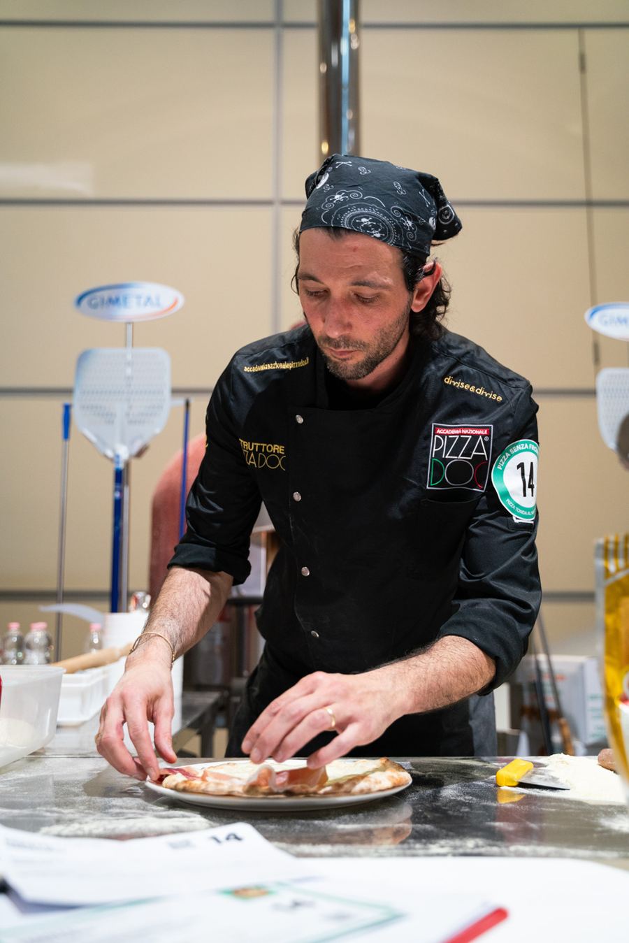 Gregorio Parietti rolling out a pizza with a rolling pin